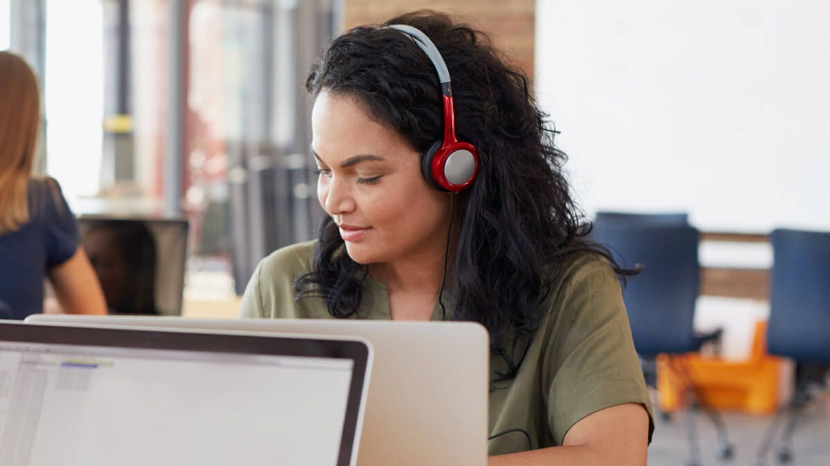 Person with headphones working on a laptop