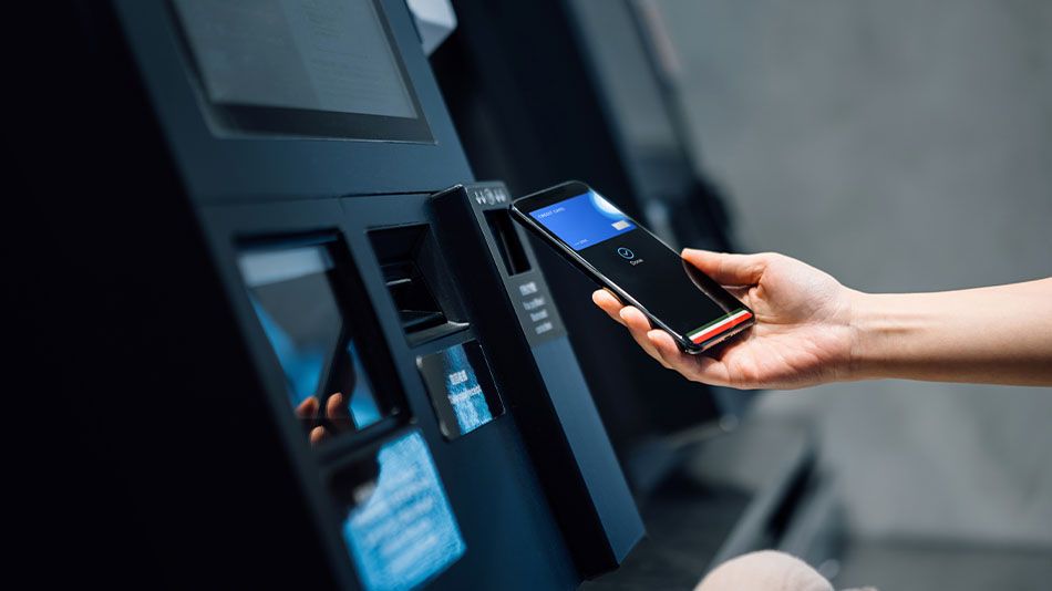person with handheld device at an ATM